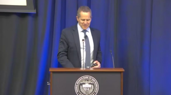 Michael Barr, Governor on Federal Reserve System Board of Governors, man in a suit standing behind podium, giving a speech