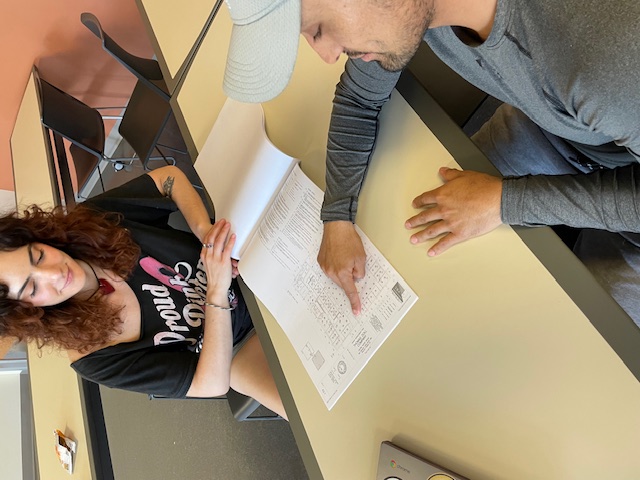 Carolynne Zimmerman and Irving Alatriste-Flores review a building blueprint, April 17, 2024, Library 121, Commercial Real Estate Student Fellows Program meeting.