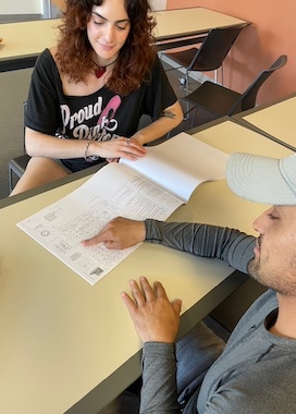 Carolynne Zimmerman and Irving Alatriste-Flores review a building blueprint, April 17, 2024, Library 121, Commercial Real Estate Student Fellows Program meeting.