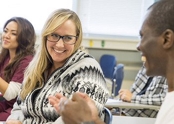 Female and male student smiling at each other in classroom