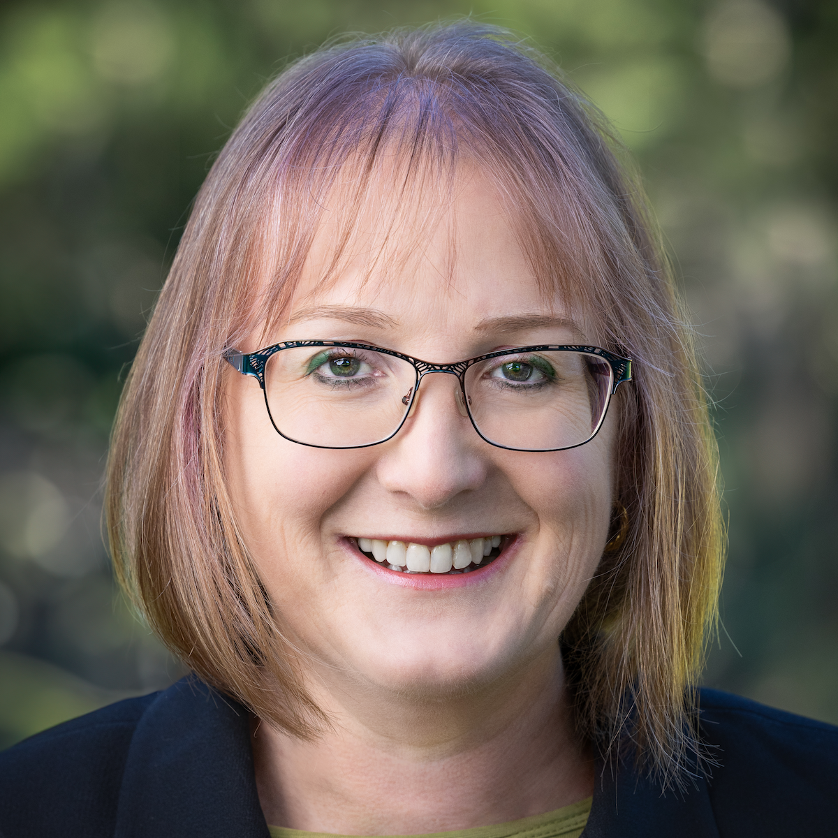 Erika Dyquisto, headshot of smiling woman with blonde hair, eye glasses, and dark blazer