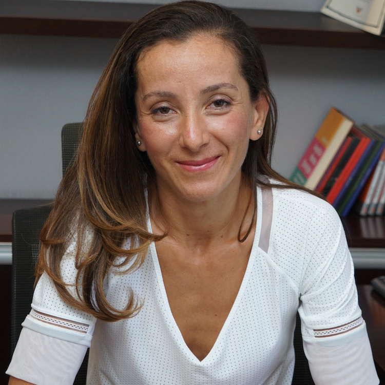 Gulnur Tumbat, woman smiling, with long, dark blonde hair wearing white top
