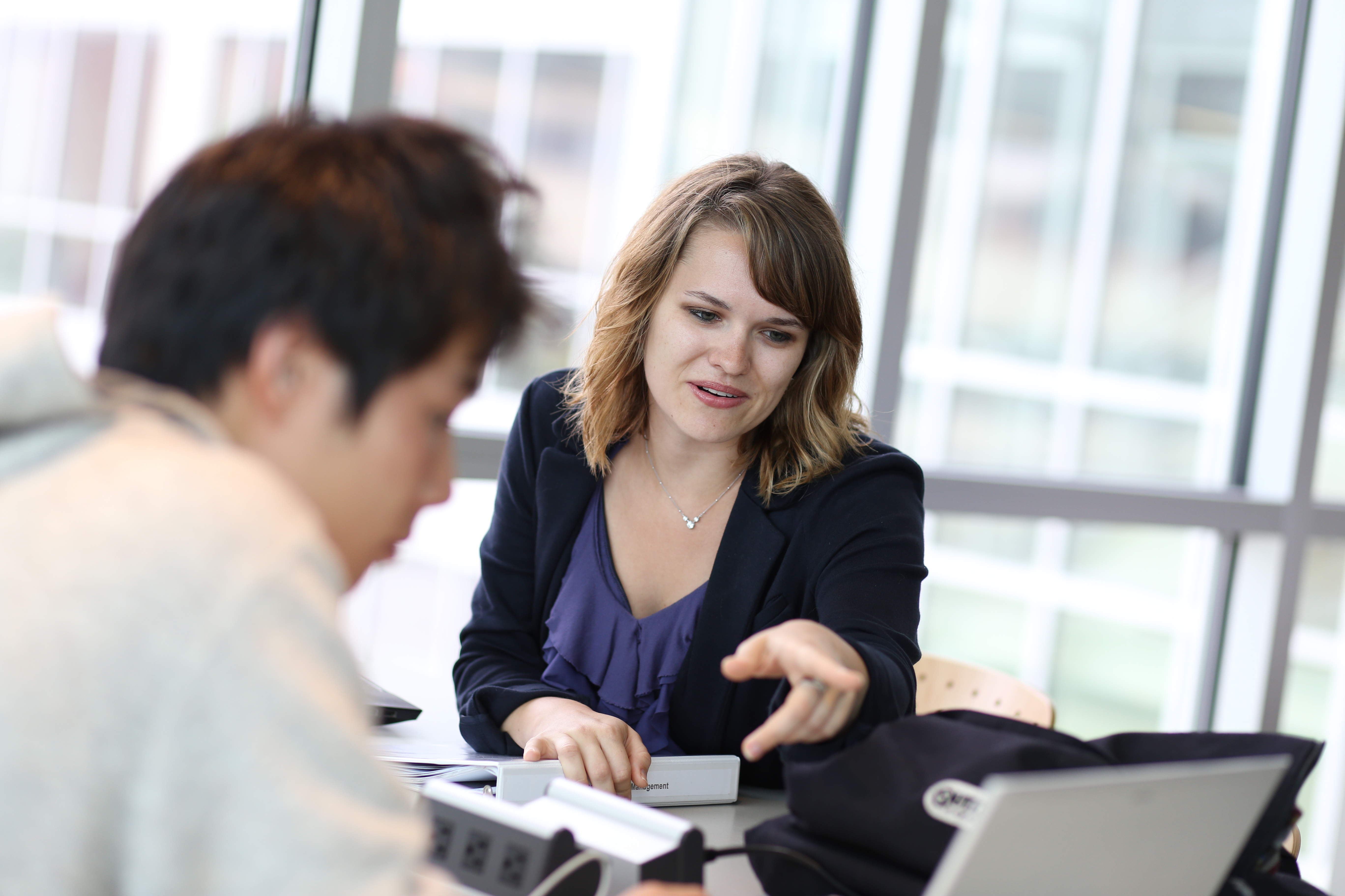 blonde female student talking with dark-haired male student