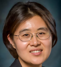 Headshot of woman with short dark hair and classes.