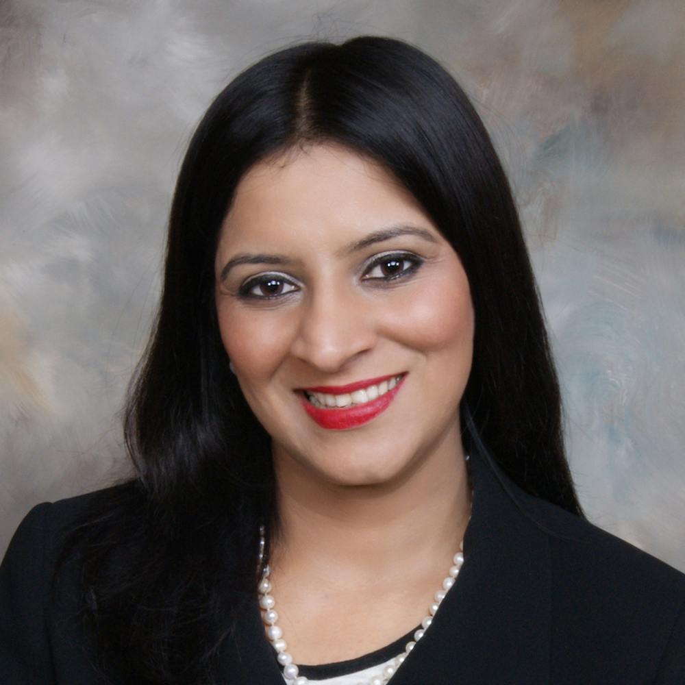Nitu Nanda, woman smiling with dark, long hair wearing dark dress