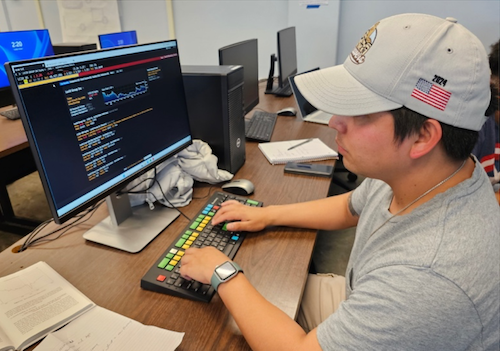Student with baseball cap using Bloomberg Terminal at San Francisco State University, Lam Family College of Business
