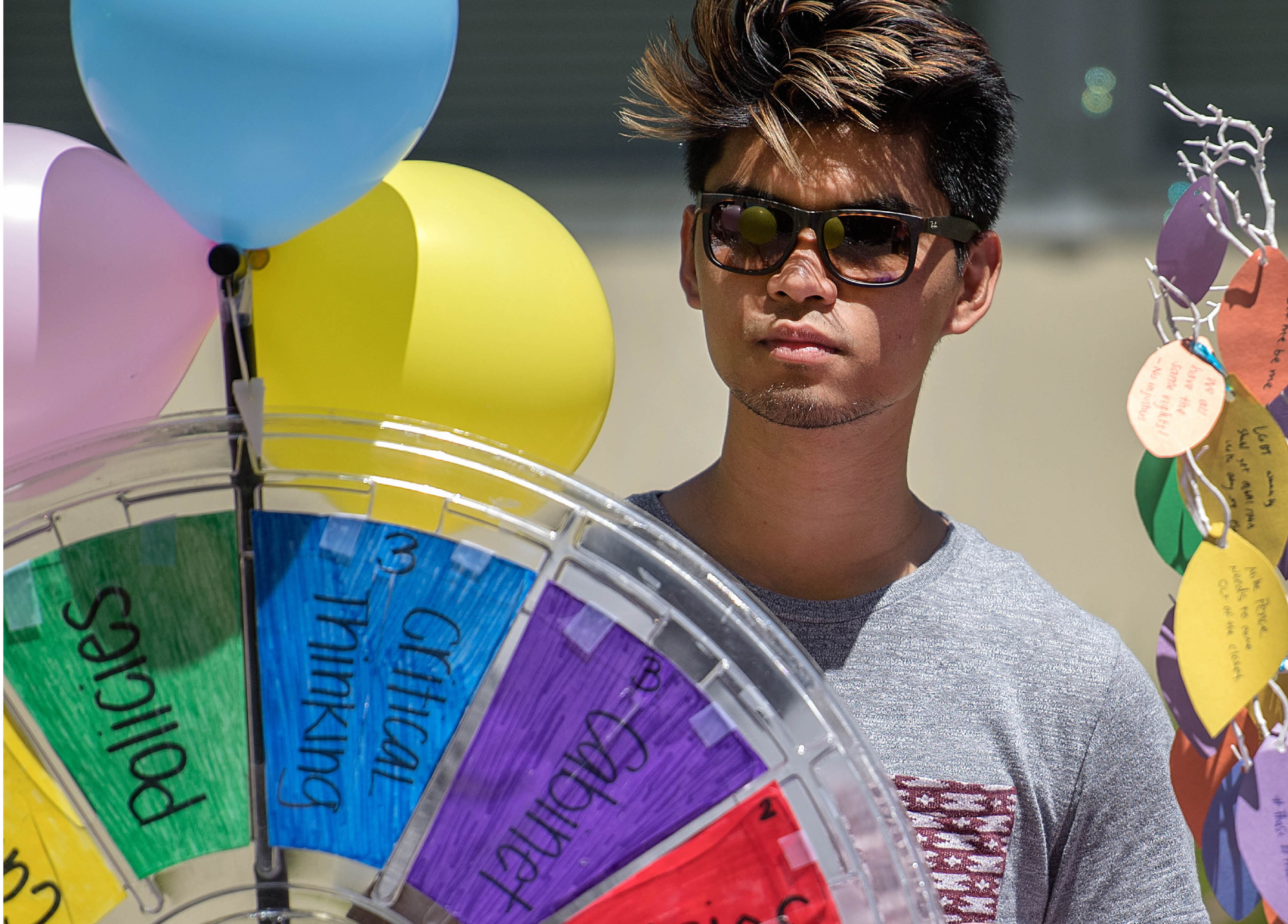 Student with sunglasses and balloons and a spinning wheel game