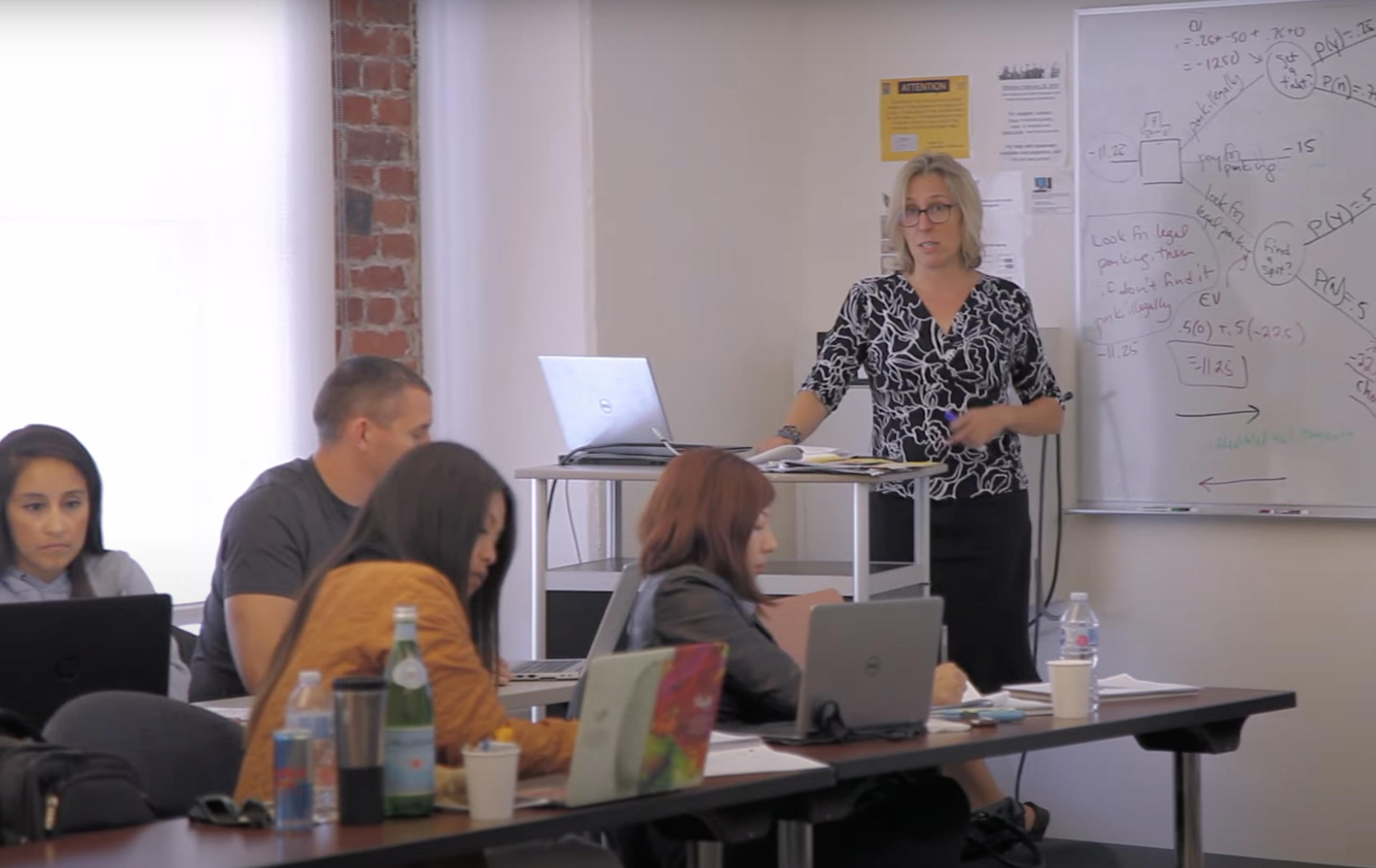 Professor teaching in a classroom of graduate students 