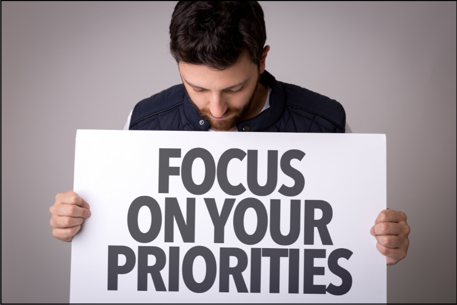 Focus on Your Priorities sign and person