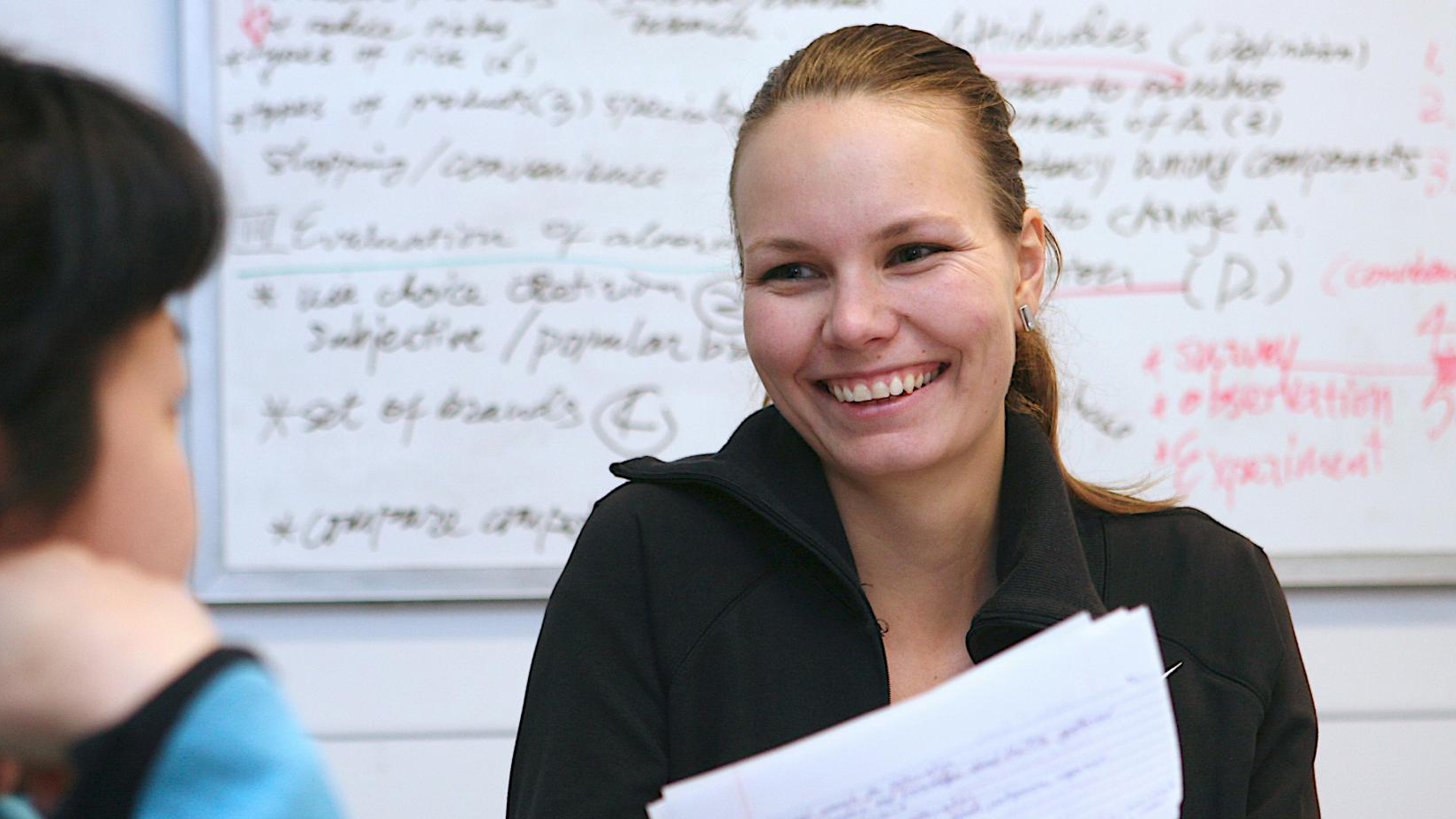 Woman smiling with papers in her hand