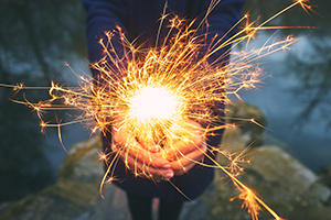 woman holding sparkler in forest winter day