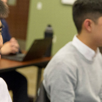 SFSU students sitting at desks in a classroom.