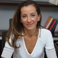 Gulnur Tumbat, woman smiling, with long, dark blonde hair wearing white top